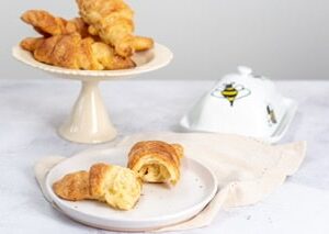 Croissant on cake stand with broken croissant on plate